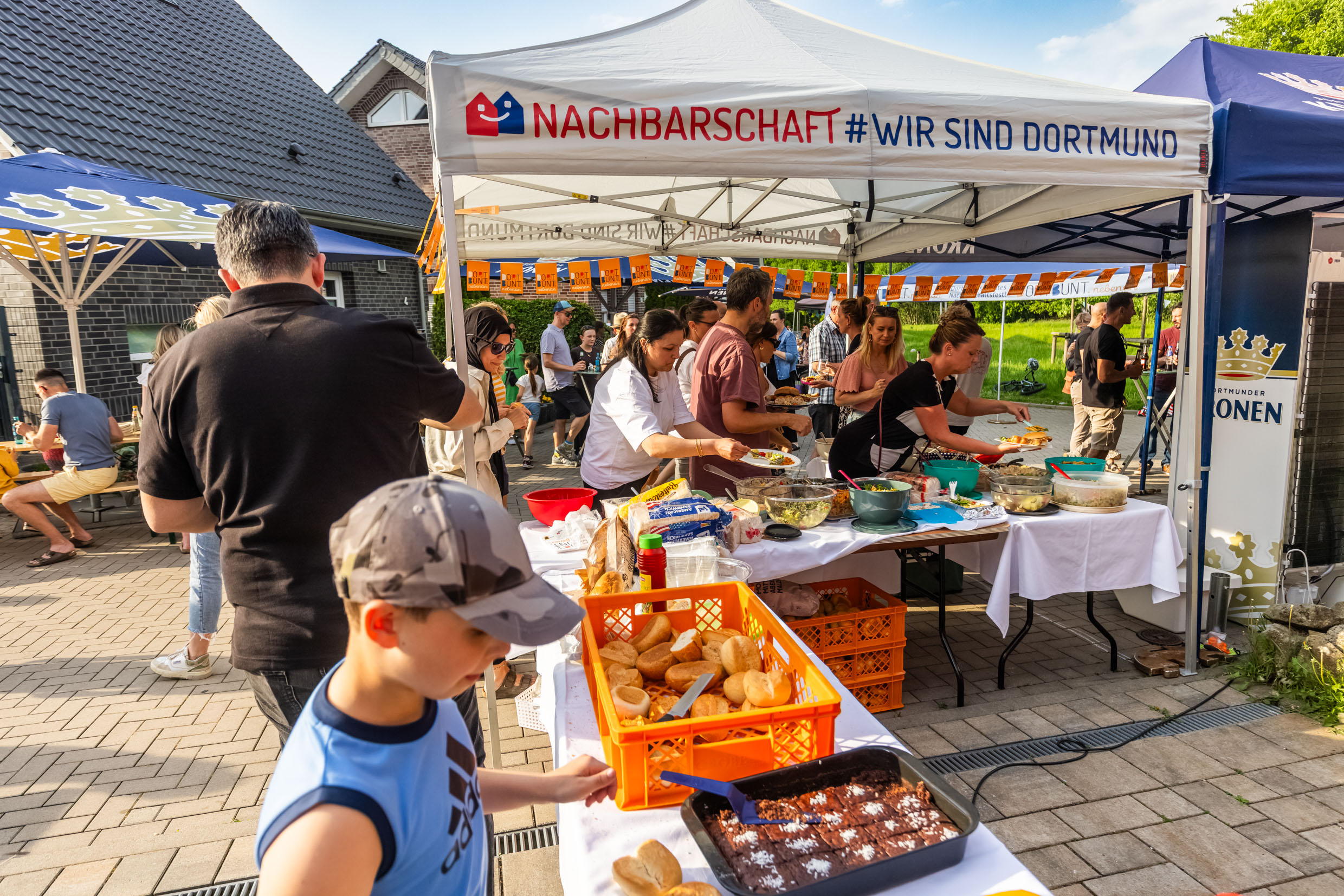 Zelt und Biertische mit Essen beim Nachbarschaftsfest in Dortmund-Rahm.
