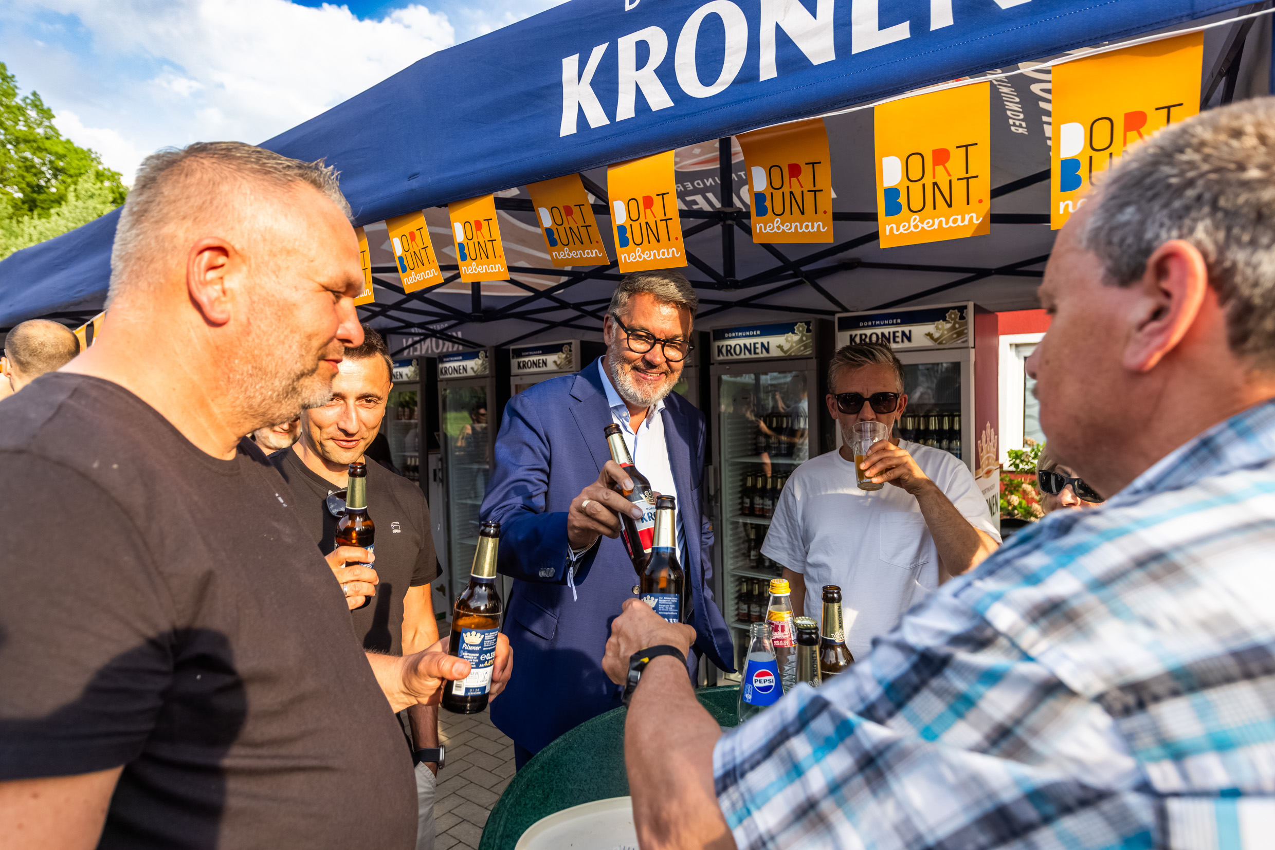 Menschen, die mit Oberbürgermeister Thomas Westphal beim Nachbarschaftsfest Rahm anstoßen.